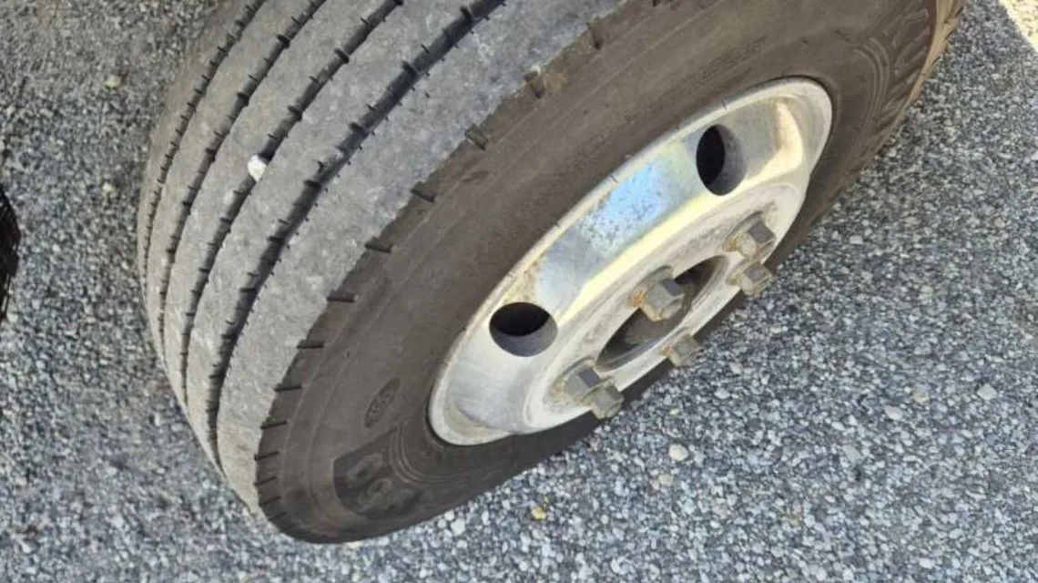 알루미늄 휠과 타이어 접지면, 휠 너트가 보이는 타타대우 더쎈 앞바퀴