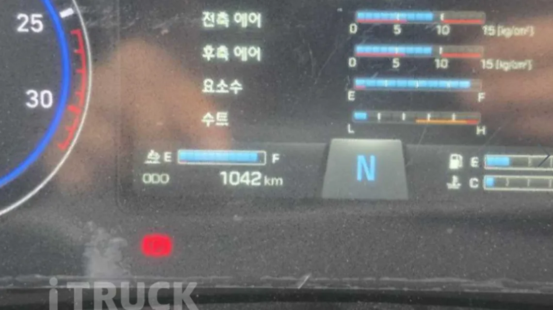 현대 파비스 계기판 클로즈업, 총 주행거리 1042km와 전축 후축 에어 게이지, 요소수 잔량이 함께 표시된 화면