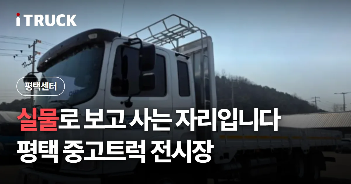 실물로 보고 사는 자리입니다, 평택 중고트럭 전시장 문구가 얹힌 평택 전시장에 선 흰색 카고 트럭 사진