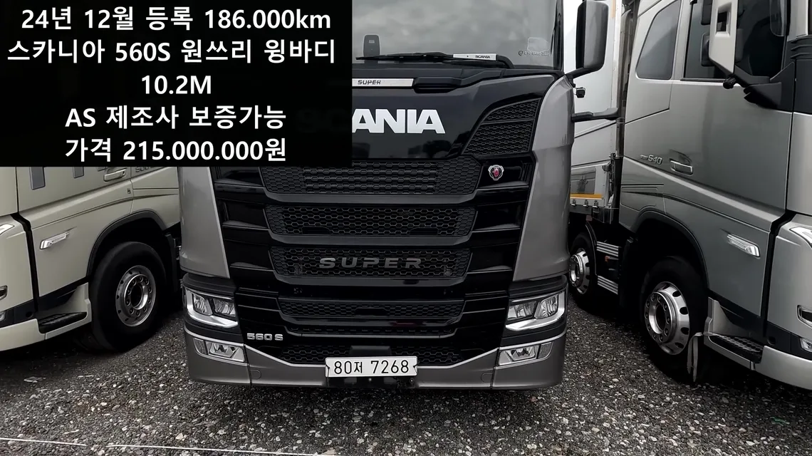 흰 번호판을 단 검은색 스카니아 S 560 정면과 함께 24년 12월 등록, 186,000km, 원쓰리 윙바디 10.2M, 가격 215,000,000원 자막이 나온 영상 화면
