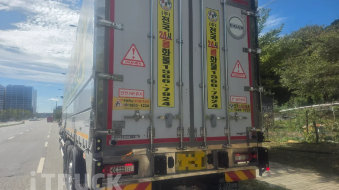 경고 스티커가 붙은 볼보 FH 540 상승윙바디 적재함 후문